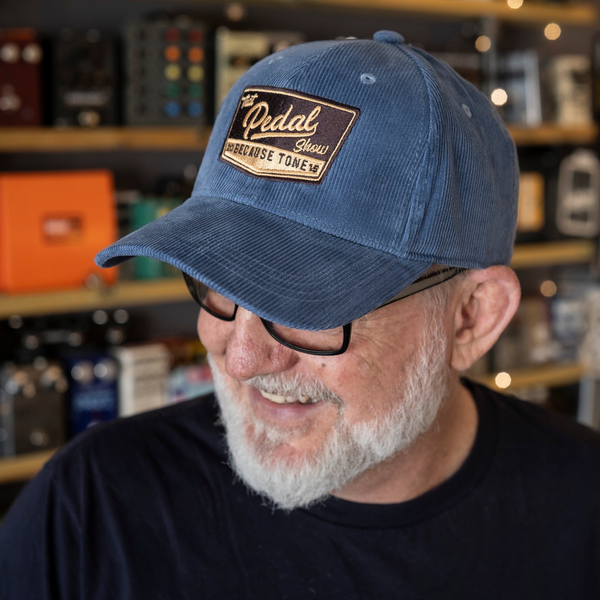 Dan wears Slate Blue corduroy baseball cap with vintage That Pedal Show logo embroidered onto front.