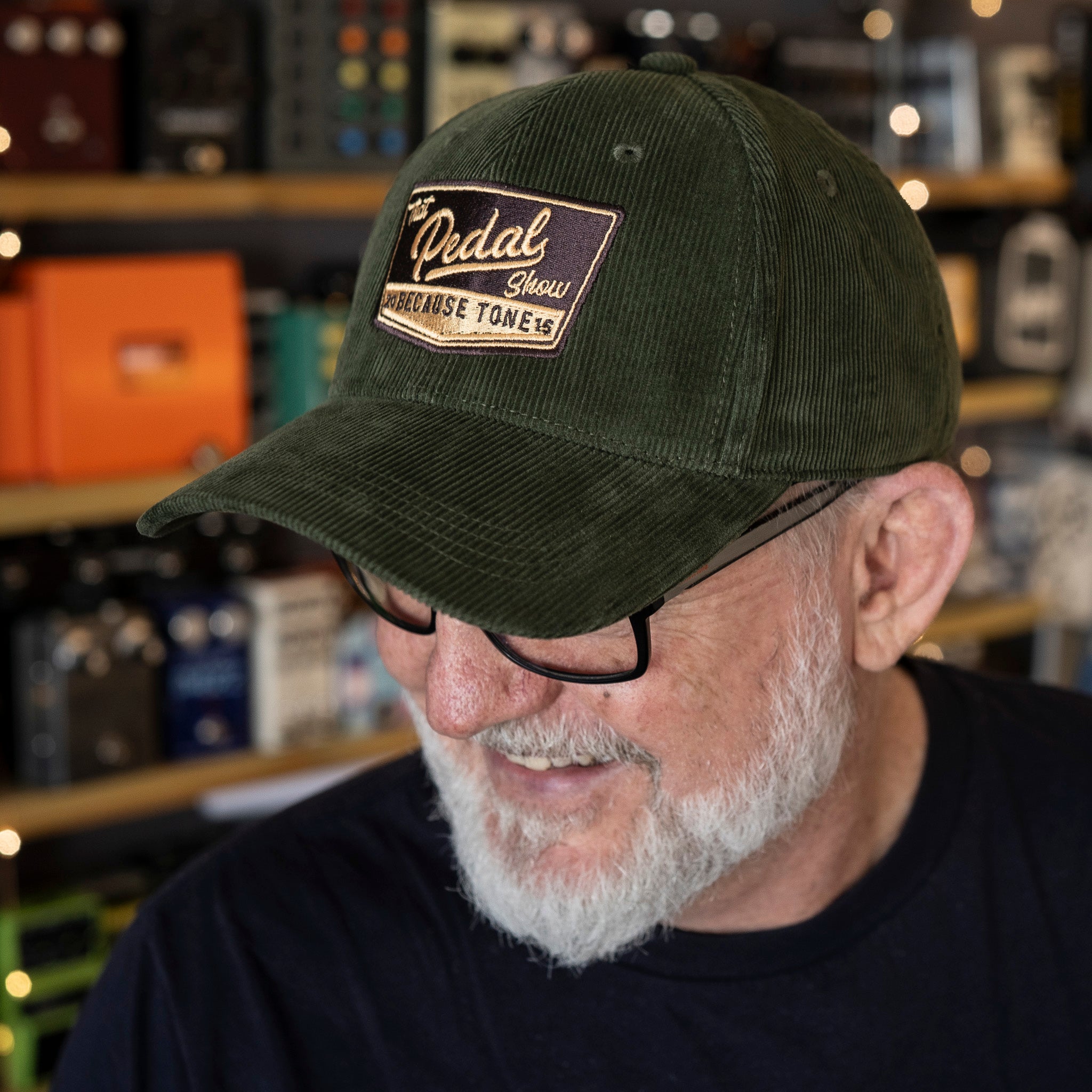 Dan wears Forest Green corduroy baseball cap with vintage That Pedal Show logo embroidered onto front.