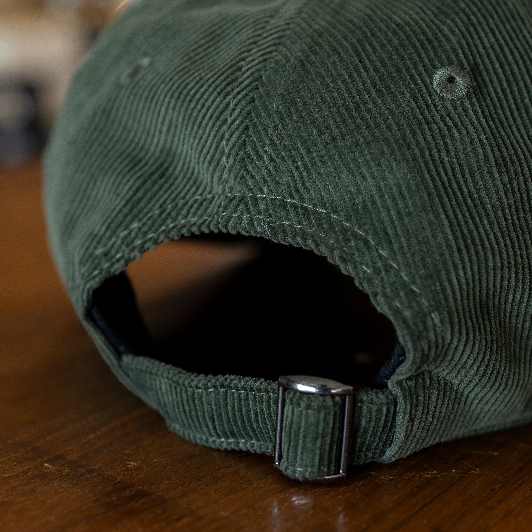 Close up of adjustment strap on a corduroy baseball cap
