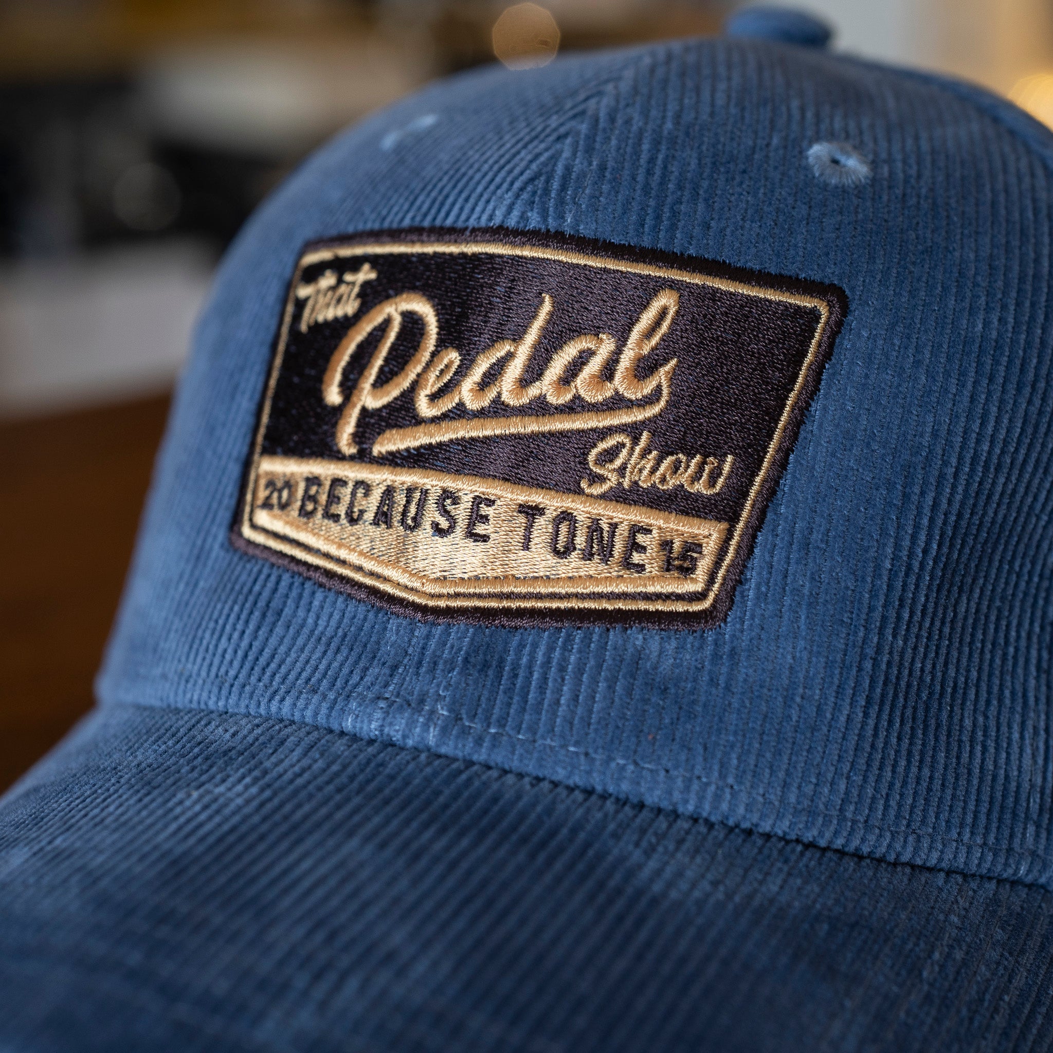Close up of Slate Blue corduroy baseball cap with vintage That Pedal Show logo embroidered onto front.