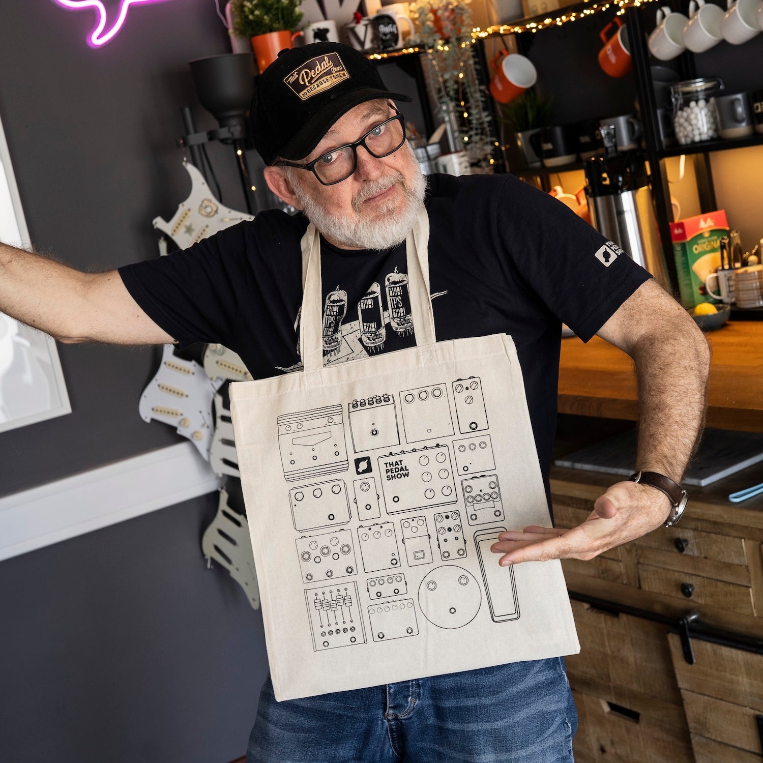Ever stylish Dan from That Pedal Show proudly wears his Tote Of Tone cotton tote bag printed with black line drawings of various guitar pedals.